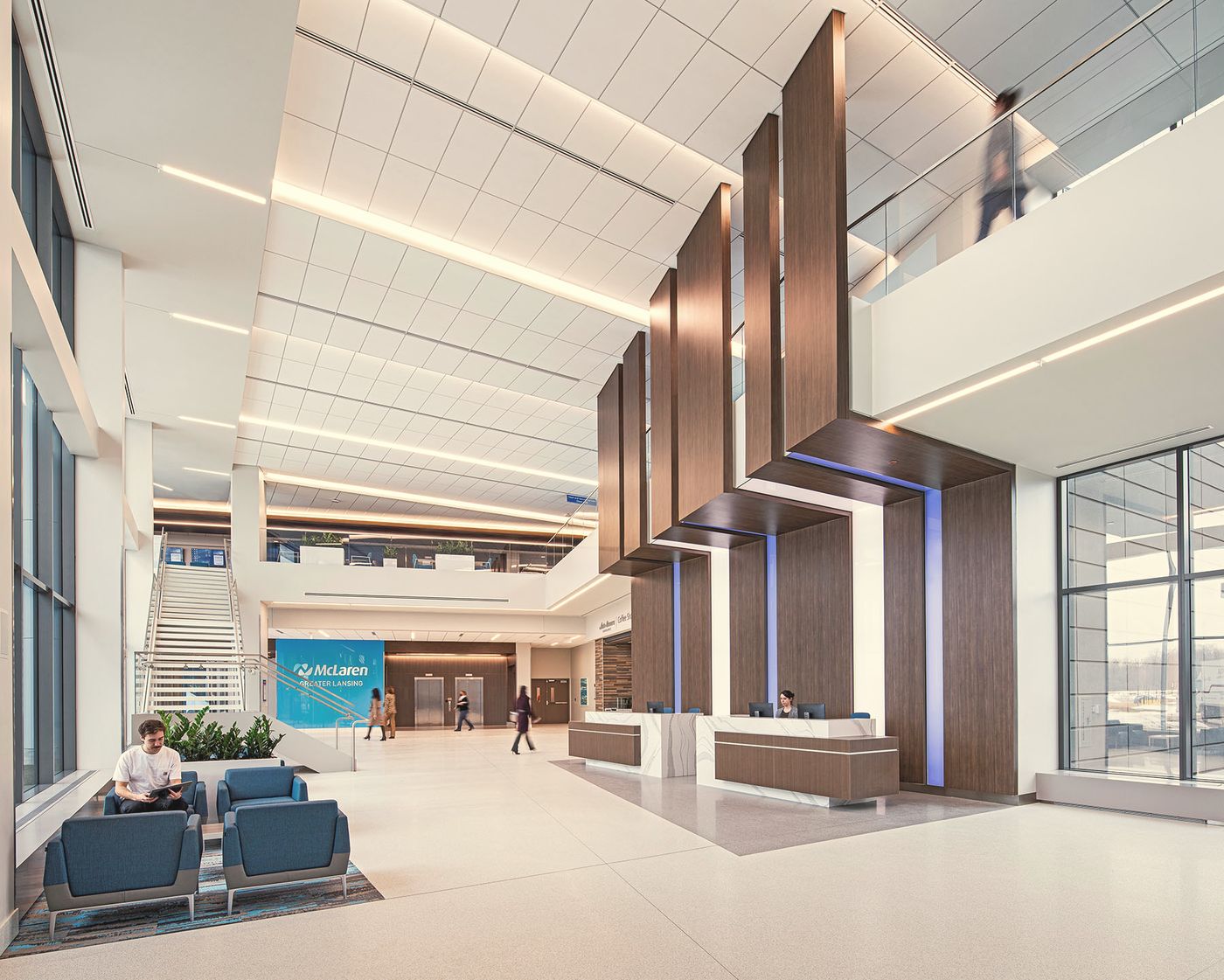 A tall, light-filled healthcare atrium with wood panels